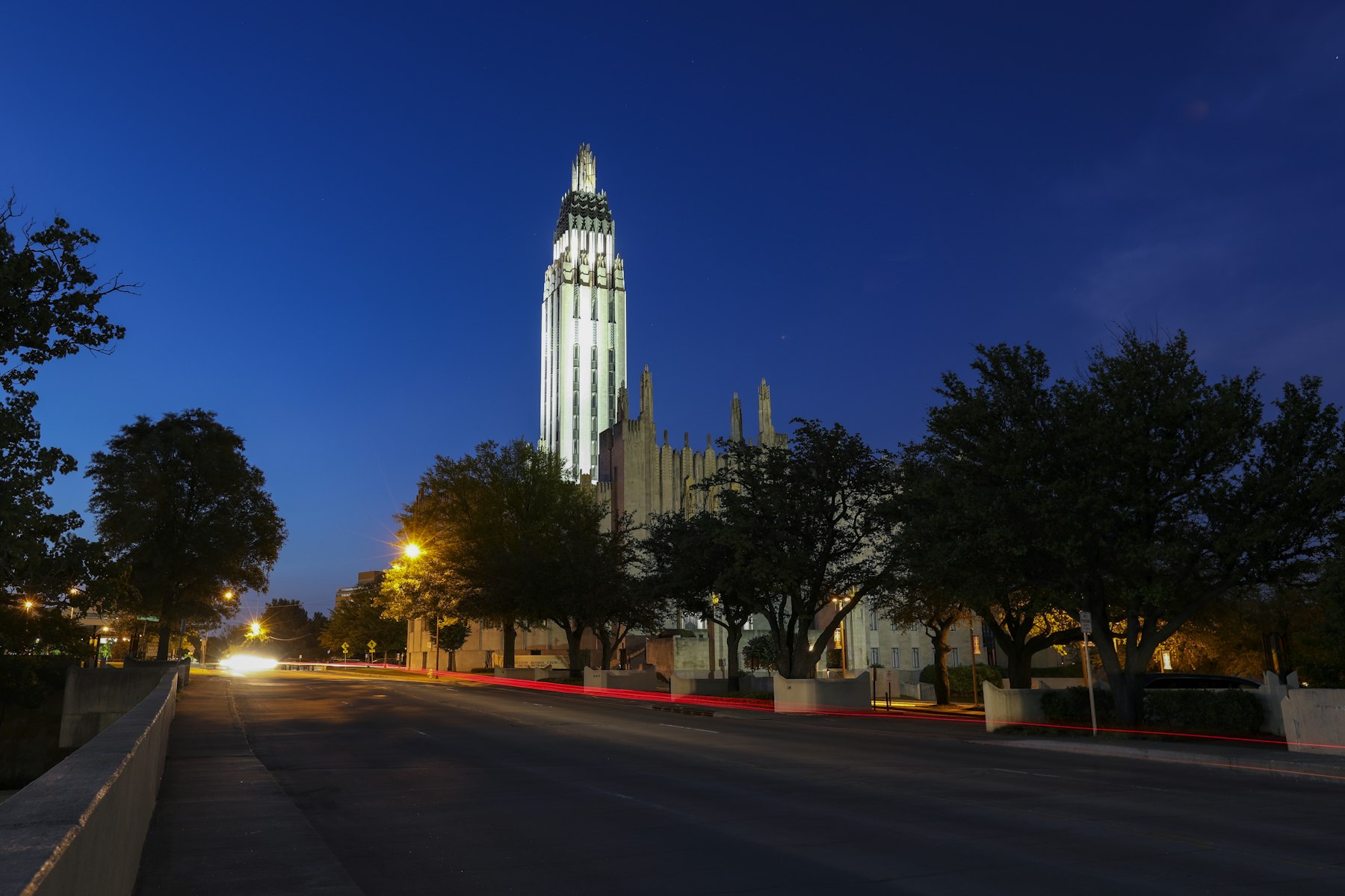 Boston Avenue Church in Tulsa lit up at night with light trails from passing traffic