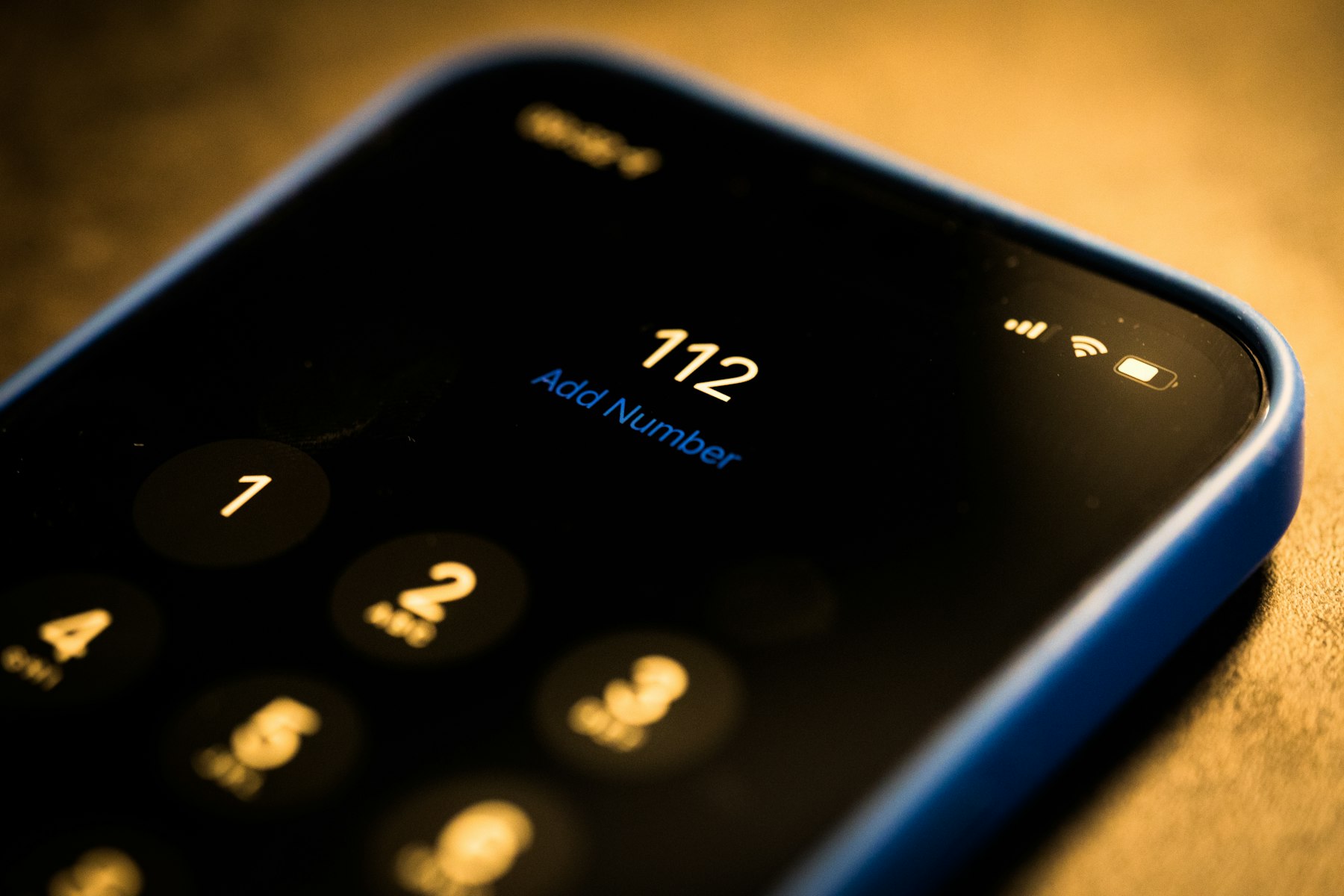 A close-up of a smartphone dial pad resting on a wooden surface