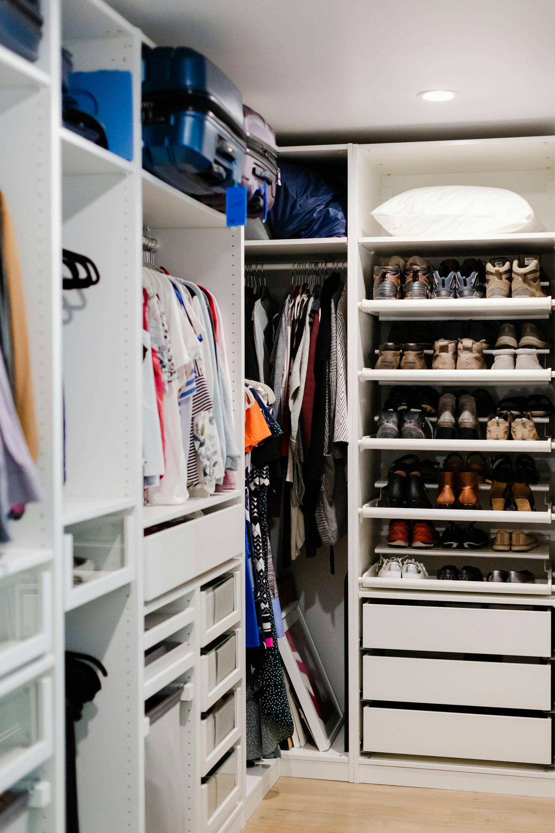 A neatly organized custom closet system with shelving and hanging rods