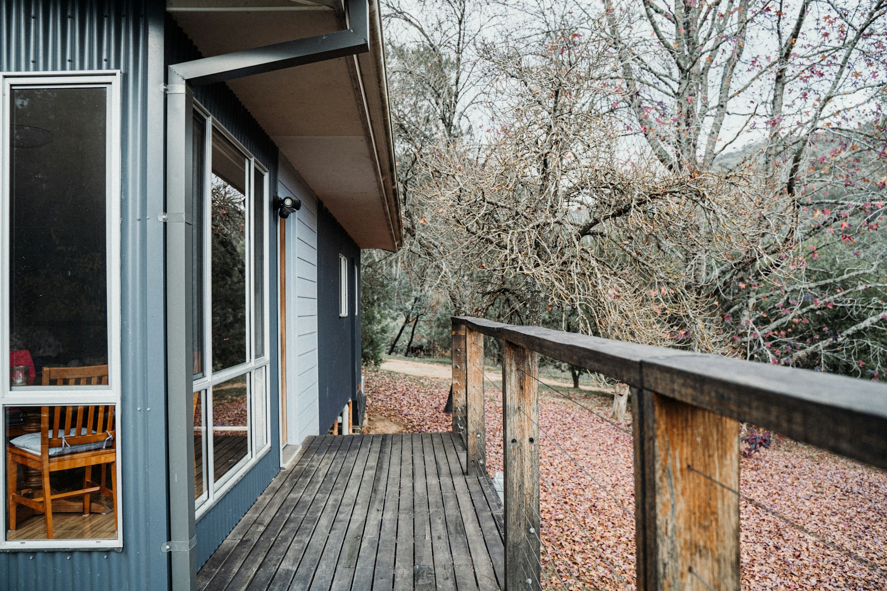 A wooden backyard deck with a table and chairs