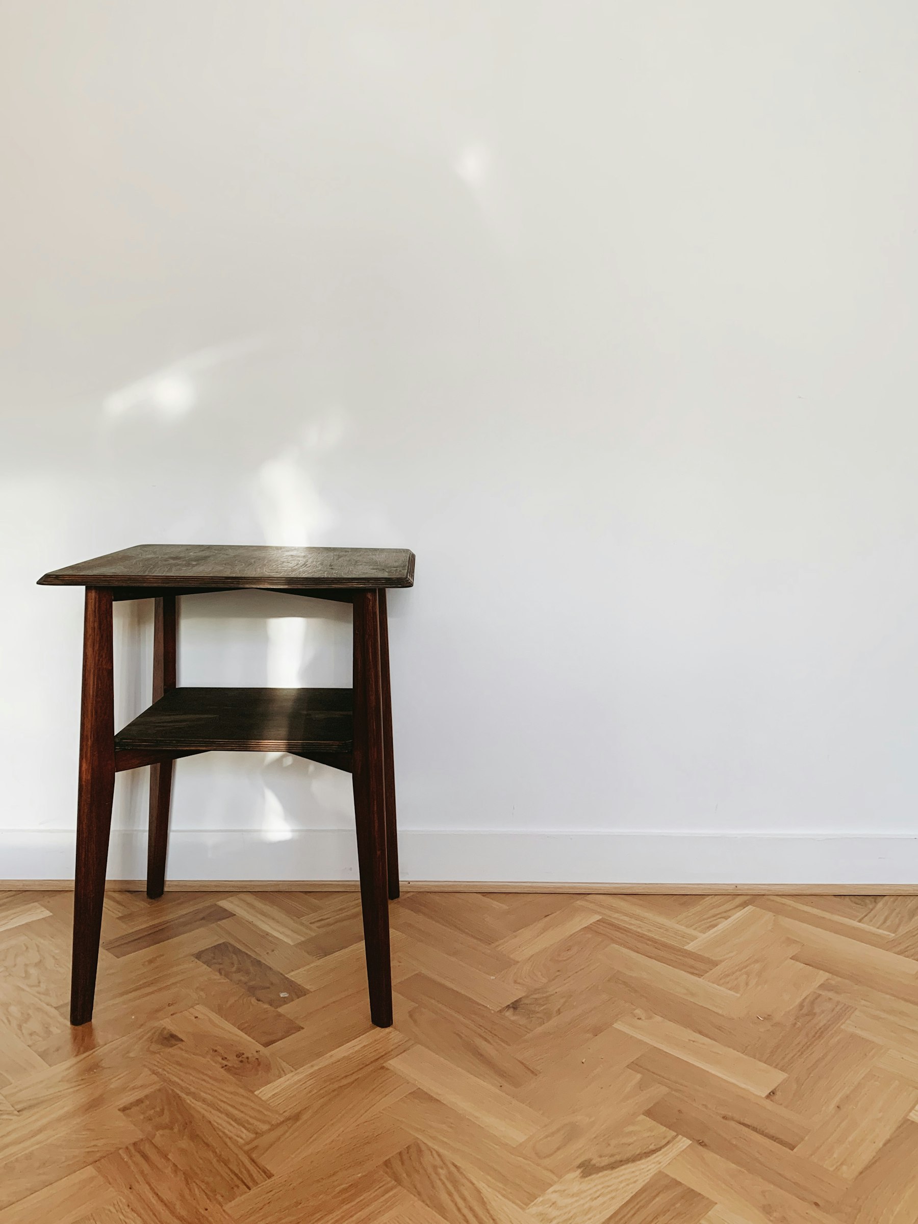 A close-up of a wooden chair on a parquet hardwood floor