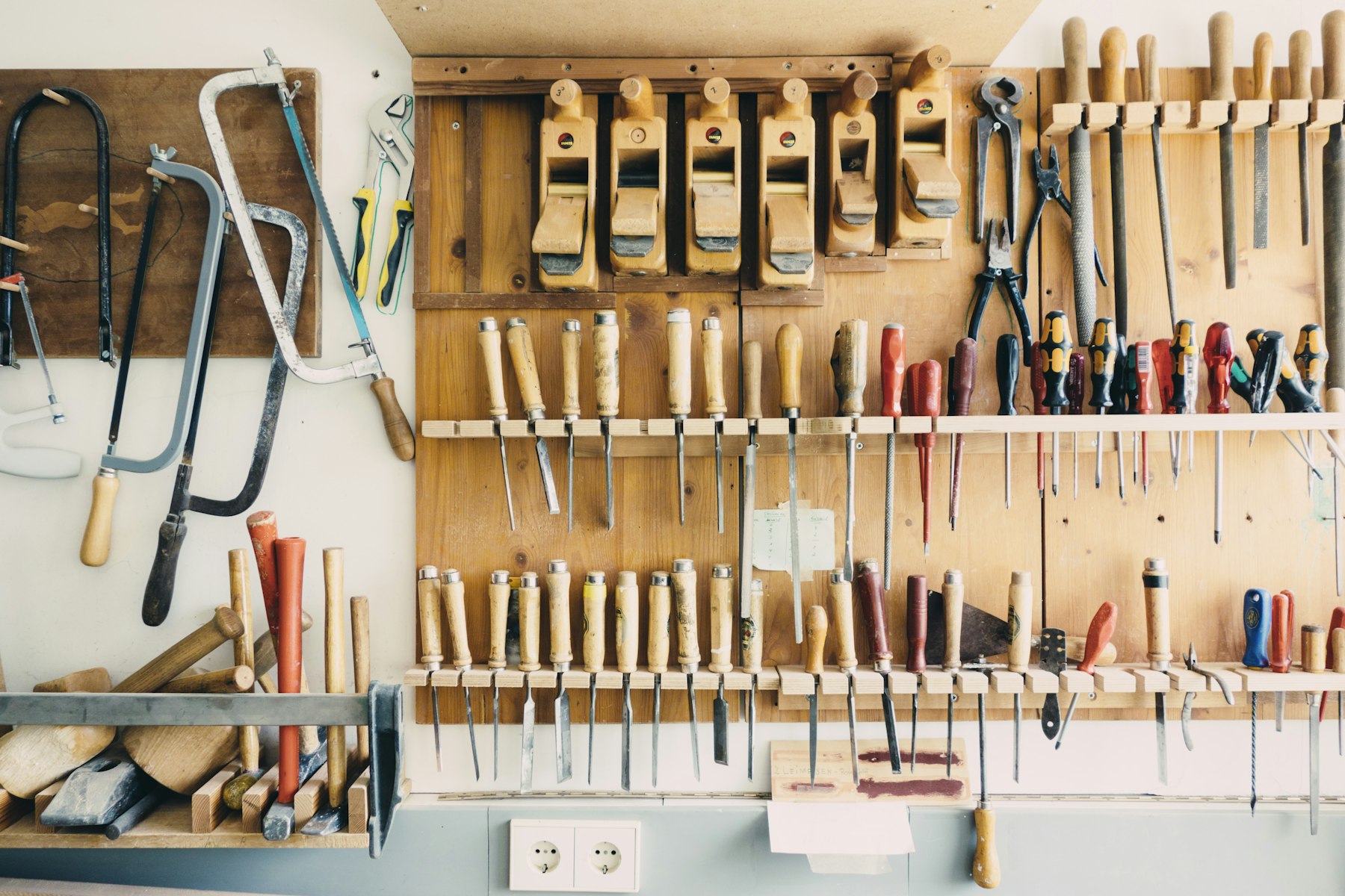 Assorted handheld tools arranged in a tool rack