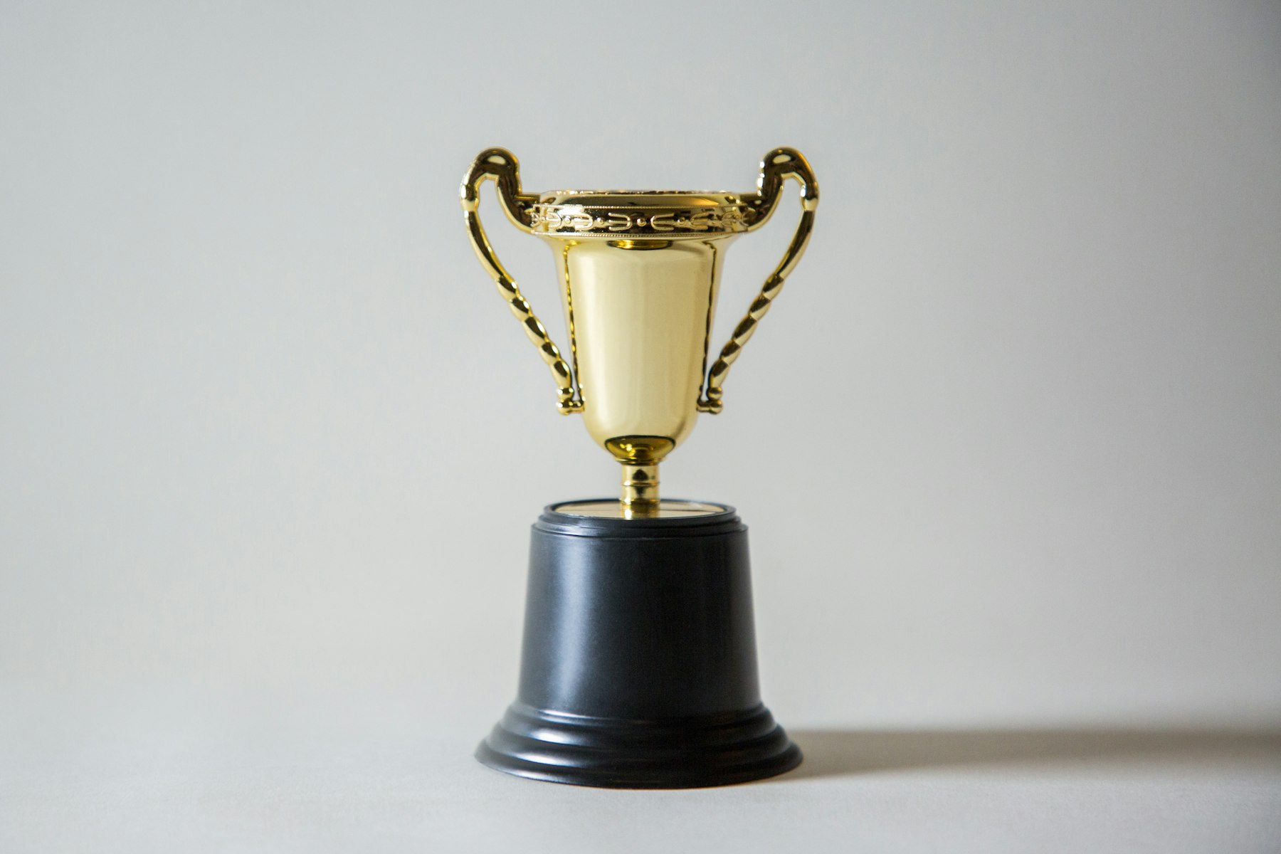 A small gold trophy on a plain neutral background
