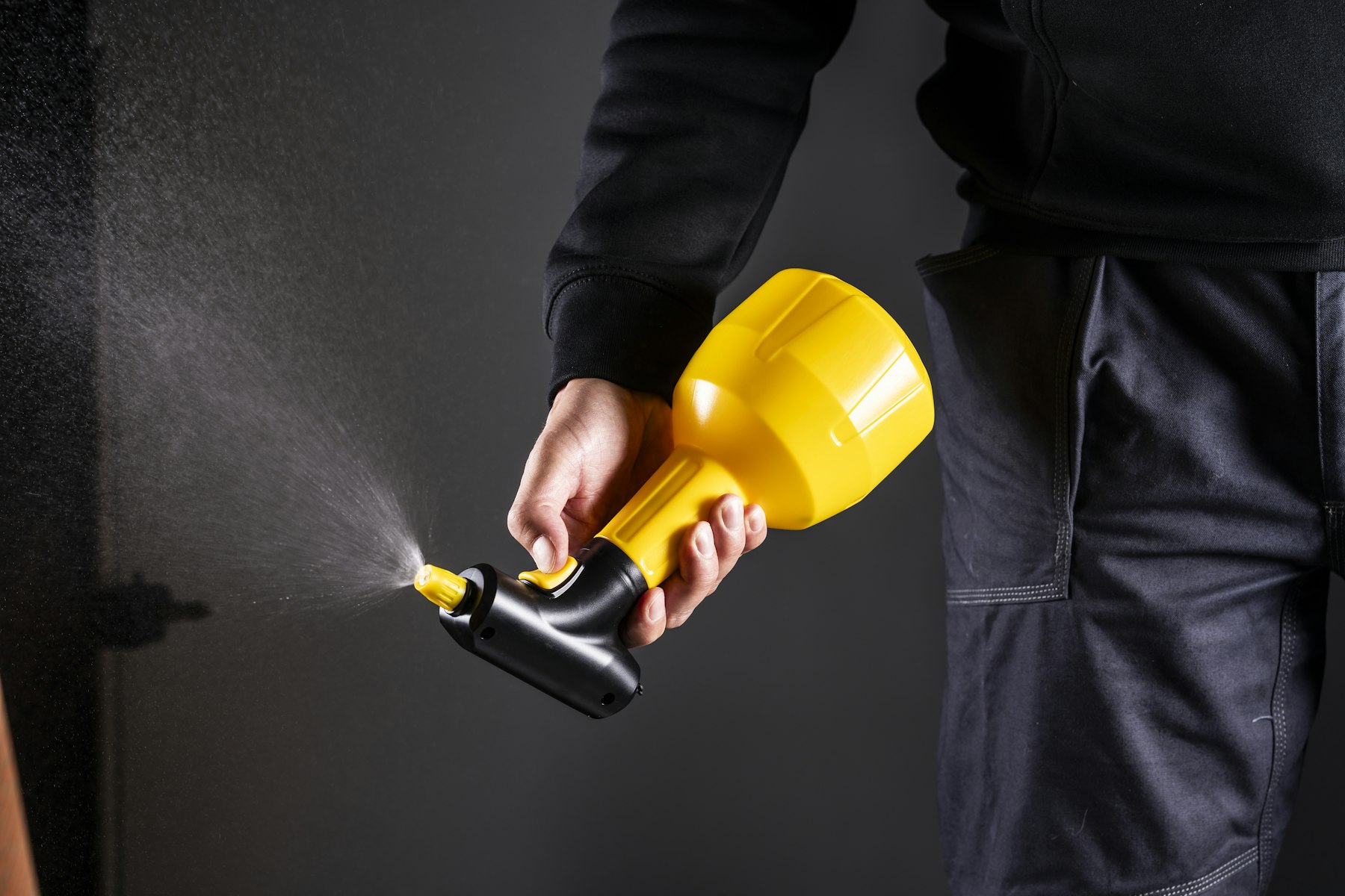 A pest control technician holding a spray gun