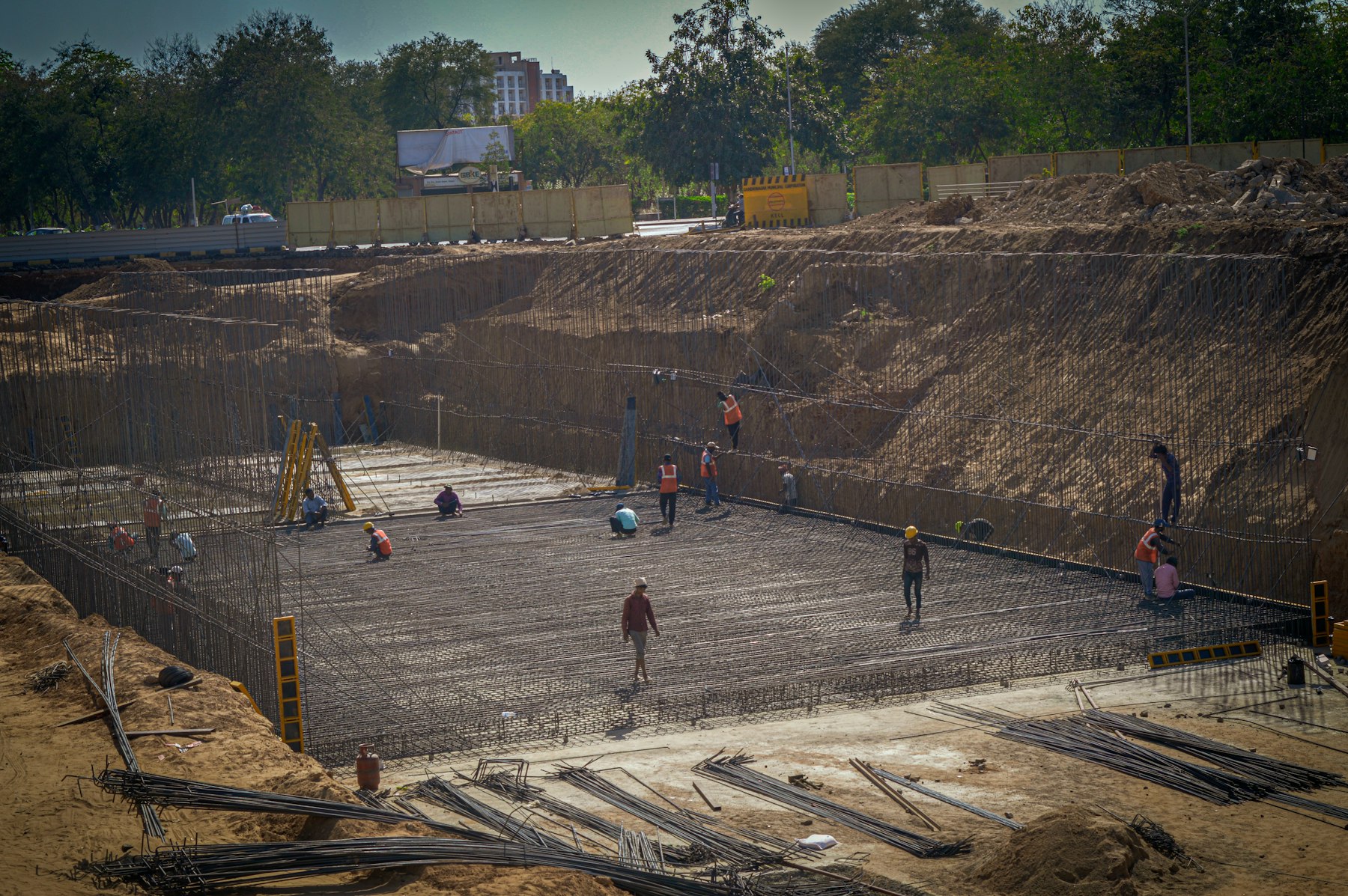 A large in-ground pool excavation site with rebar grid and construction crew