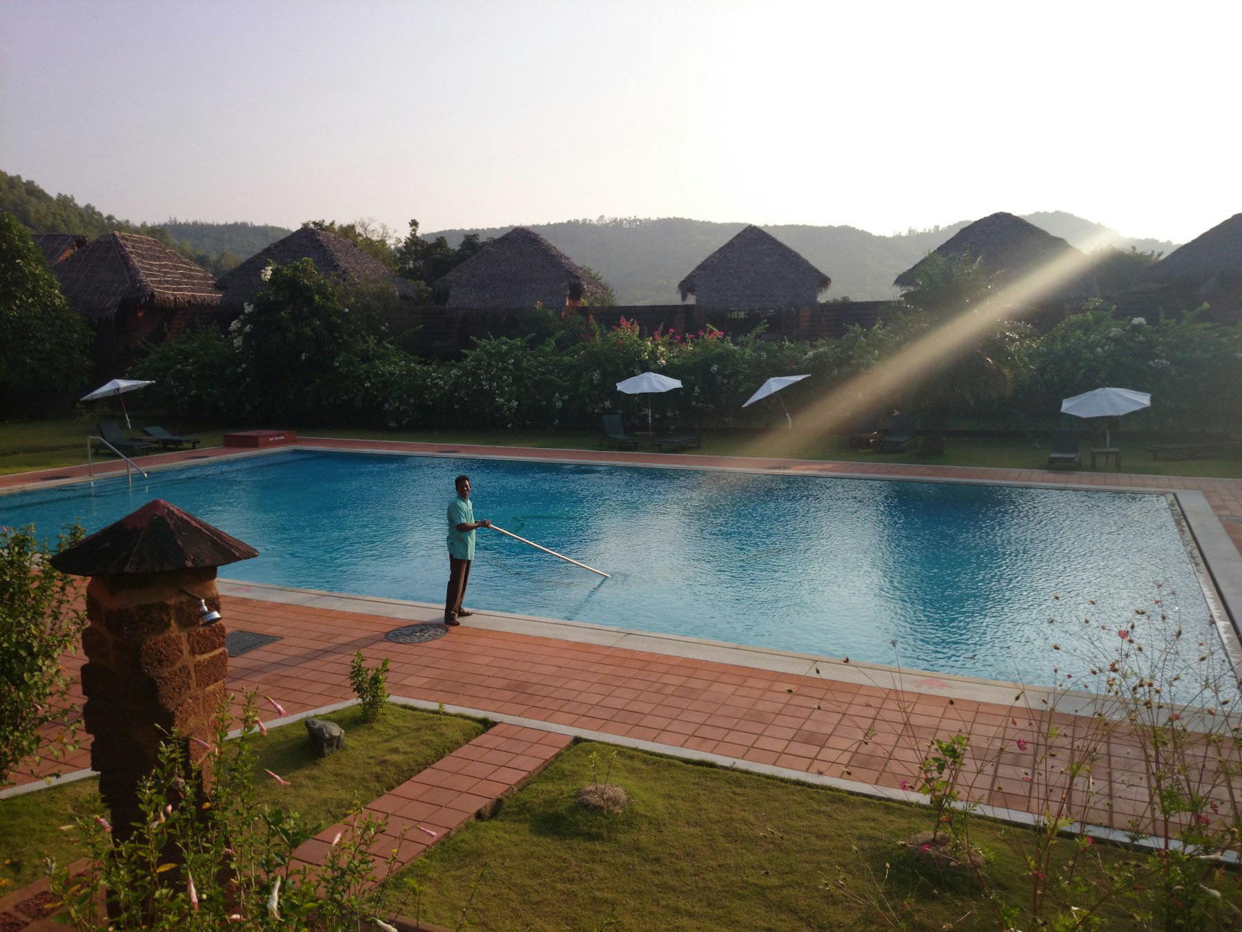 A pool technician cleaning a residential swimming pool