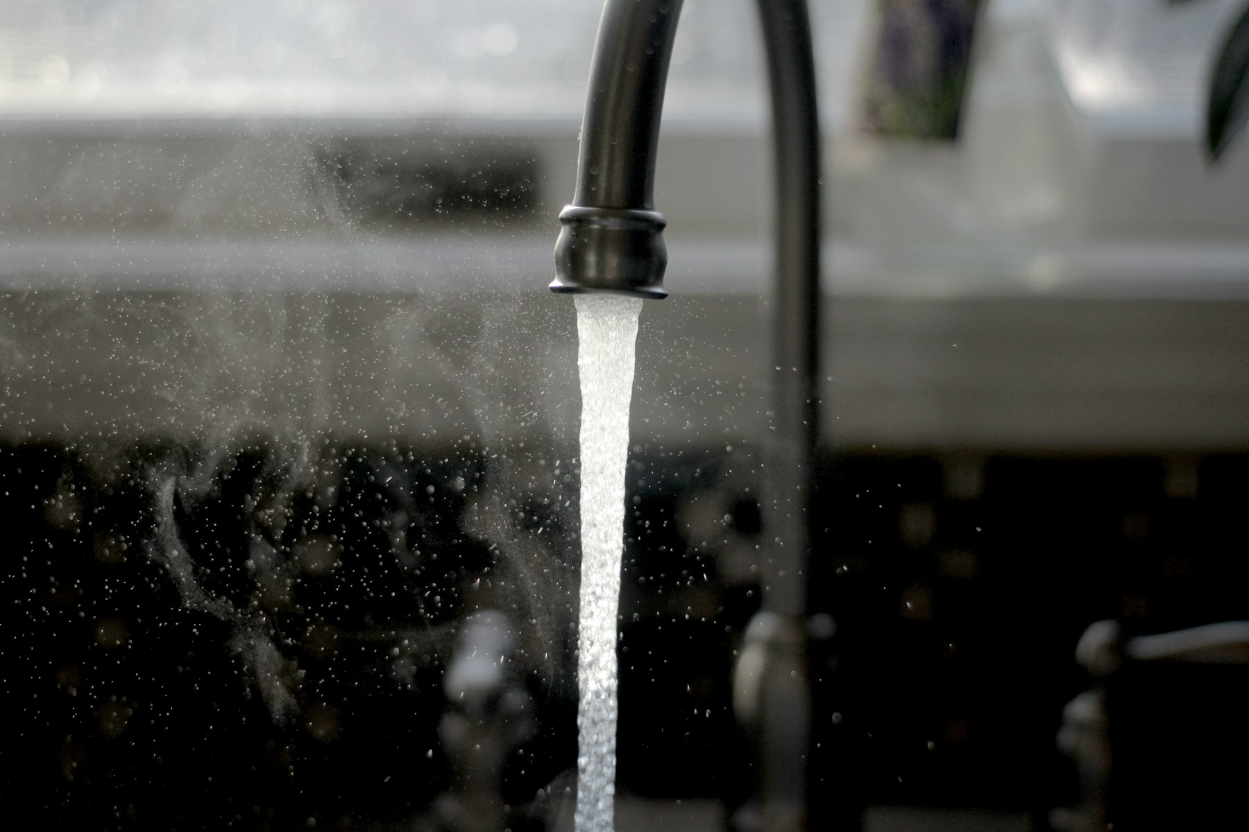 Water running from a black kitchen faucet