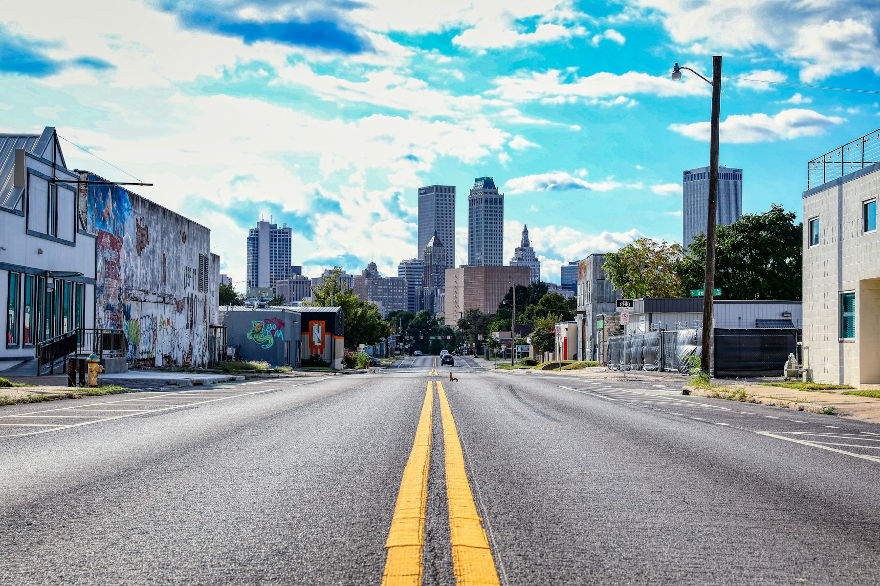 A downtown Tulsa street running straight toward the skyline