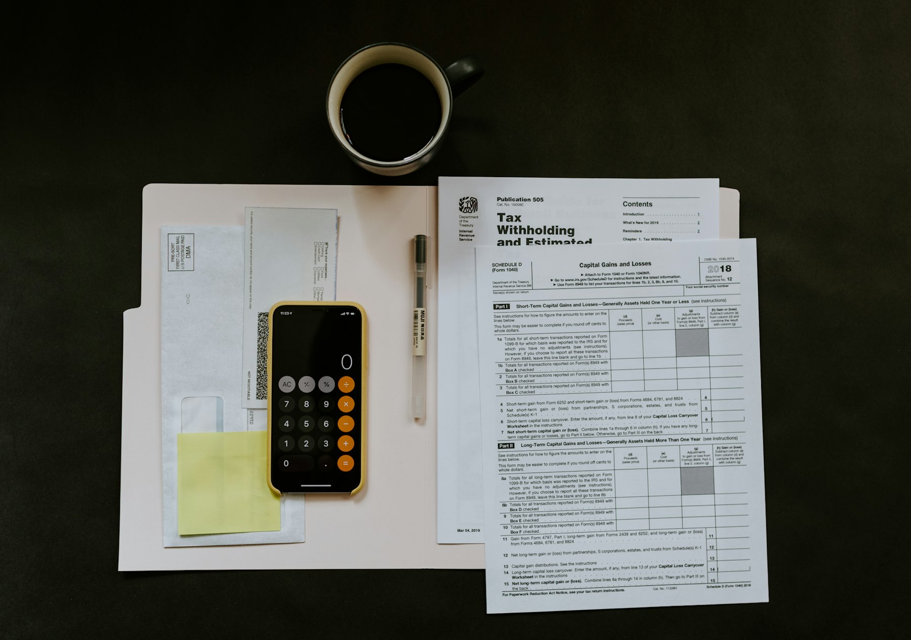 A calculator, pen, and paperwork laid out on a desk